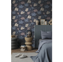 Vliesbehang met een groot bloemenpatroon in een modern ingerichte slaapkamer met een grijs bed en een decoratieve bijtafel.