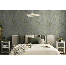 Lichte slaapkamer met botanisch behang, bed met stoffen hoofdbord, groene en beige kussens en witte ronde nachtkastjes.