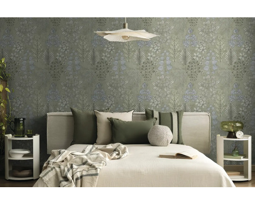 Lichte slaapkamer met botanisch behang, bed met stoffen hoofdbord, groene en beige kussens en witte ronde nachtkastjes.