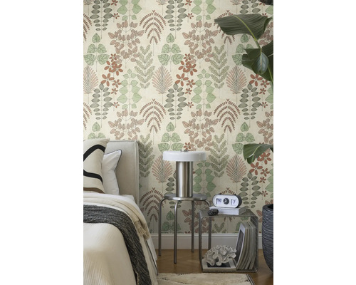 Moderne slaapkamer met vliesbehang met botanisch patroon van verschillende bladeren naast een bed en metalen bijzettafels.