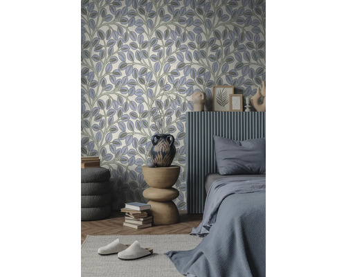 Moderne slaapkamer met behang met bladpatroon. Bed met grijs beddengoed, geribbeld wandelement en een houten tafel met vaas.