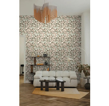 Woonkamer met behang met bladpatroon, witte gestoffeerde bank, donkere salontafel, visgraatparket en moderne kroonluchter.