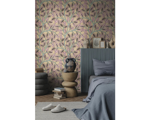 Vliesbehang met bladpatroon in roze en grijs in een modern ingerichte slaapkamer met grijs bed en houten bijtafel.