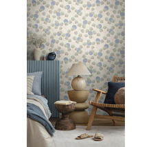 Vliesbehang met ginkgobladmotief en cirkels in een lichte kamer met houten meubels, tafellamp en bed.
