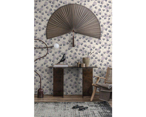 Vliesbehang met ginkgobladpatroon in een modern ingerichte woonkamer met consoletafel, wandwaaier en fauteuil.