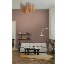Moderne, lichte woonkamer met een witte bank, donkere salontafel, booglamp en wandplank op visgraatparket voor een muur.