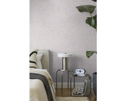 Moderne slaapkamer met lichtpaars structuurbehang, een metalen lamp op een krukje en een grote groene kamerplant.