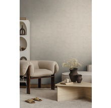 Gestructureerde wandafwerking in beige in een modern ingerichte woonkamer met fauteuil en salontafel.