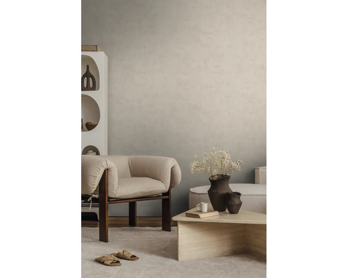 Gestructureerde wandafwerking in beige in een modern ingerichte woonkamer met fauteuil en salontafel.