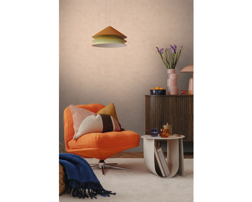 Modern ingerichte woonkamer met een oranje fauteuil, een kussen met patroon, een drielaagse hanglamp och een houten dressoir.