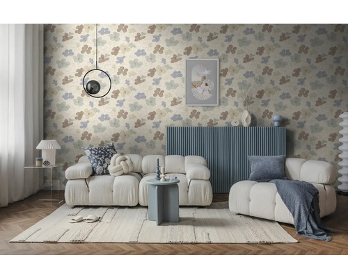 Moderne woonkamer met vliesbehang met bloemenpatroon, witte modulaire bank, blauw dressoir en licht vloerkleed op visgraatparket.