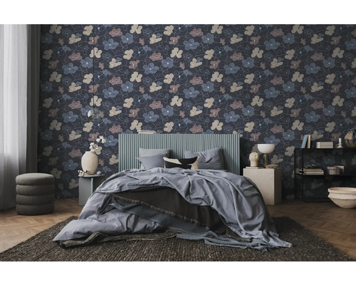 Vliesbehang met bloemenpatroon in een modern ingerichte slaapkamer met grijs bed en donker tapijt.