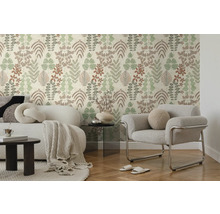 Moderne woonkamer met vliesbehang met bladmotief, witte bank met deken en grijze fauteuil op parketvloer.