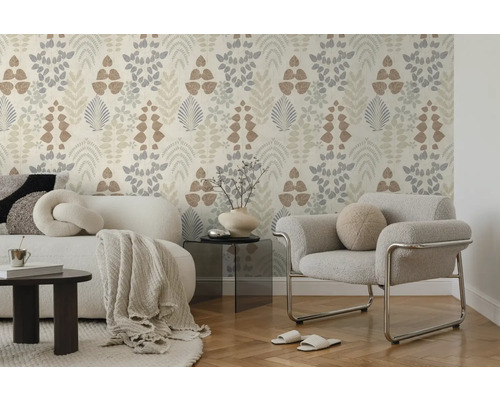 Licht vliesbehang met botanisch bladpatroon in een modern ingerichte woonkamer met bank, fauteuil en parketvloer. Helder en georganiseerd.
