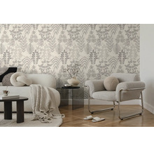 Behang met botanisch bladmotief in een modern ingerichte woonkamer met bank, fauteuil en parketvloer.