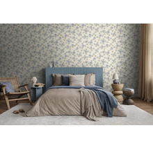 Moderne slaapkamer met vliesbehang met bloemenpatroon, blauw hoofdbord, bruin beddengoed, houten meubels en licht tapijt.