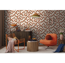 Moderne woonkamer met behang met bloemmotief, een donker dressoir, een oranje draadfauteuil en een gestoffeerde fauteuil op een licht tapijt.