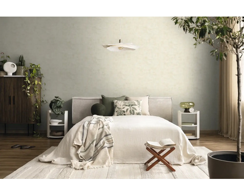 Licht ingerichte slaapkamer met bed, kussens met patroon, twee witte nachtkastjes, een hanglamp en gestructureerd behang op de muur.