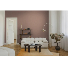 Moderne woonkamer met witte modulaire bank, donkerhouten salontafel en een booglamp voor een oudroze muur.