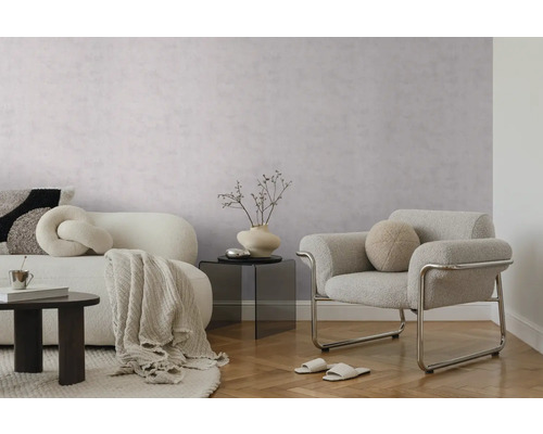 Moderne woonkamer met lichtgrijs behang met textuur, een witte bank, een grijze fauteuil met metalen frame en een lichte parketvloer.