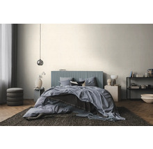 Moderne, lichte slaapkamer met een bed met een blauw, verticaal geribbeld hoofdbord, blauw beddengoed en een visgraatparketvloer.