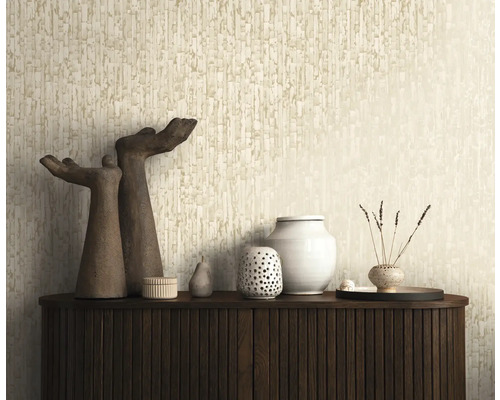 Gestructureerd behang met een verticaal patroon in beige achter een donker dressoir met decoratieve objecten en sculpturen.