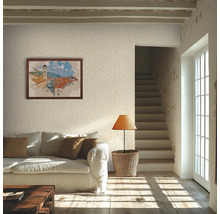 Lichte woonkamer met licht gestructureerd behang, een witte bank met bruine kussens, een rieten lamp en een ingelijste foto aan de muur.