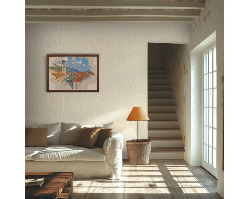 Lichte woonkamer met licht gestructureerd behang, een witte bank met bruine kussens, een rieten lamp en een ingelijste foto aan de muur.