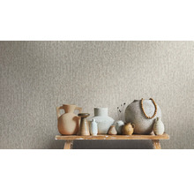 Vliesbehang met structuur, met decoratieve keramische vazen op een rustieke houten bank.