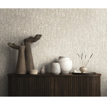 Behang met abstract verticaal structuurpatroon achter een houten dressoir met decoratieve vazen en sculpturen.