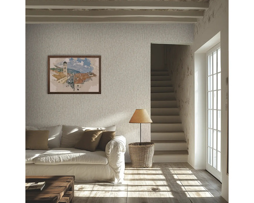Lichte woonkamer met behang met textuur, witte bank, bruine kussens, houten vloer, tafellamp op een mand en een trap.