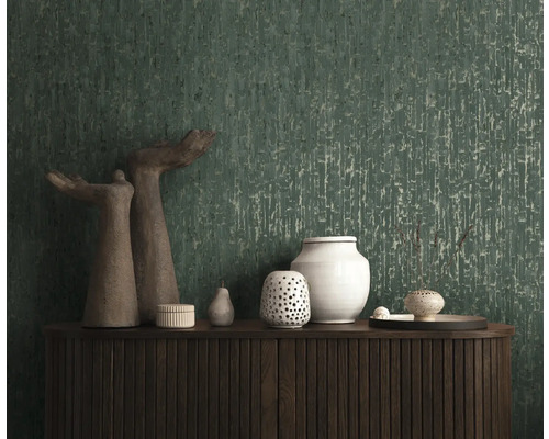 Donkergroen behang met verticale textuur achter een dressoir van donker hout met decoratieve vazen.