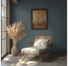 Rustieke kamer met getextureerde wand, houten stoel met rotan, vaas met pampasgras en ingelijste foto in natuurlijk daglicht.