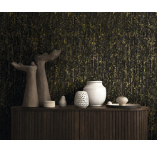 Vliesbehang met verticale structuur in zwart en goud achter een houten dressoir met decoratieve vazen en sculpturen.