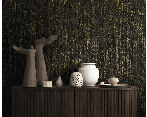 Vliesbehang met verticale structuur in zwart en goud achter een houten dressoir met decoratieve vazen en sculpturen.