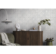 Gestructureerd vliesbehang met een subtiel patroon op een wand achter een houten dressoir en decoratie in een modern ingerichte woonkamer.