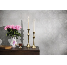 Grijs vliesbehang met vintage-structuur en subtiel patroon in een klassiek ingerichte scène met kandelaars, bloemen en een boek.