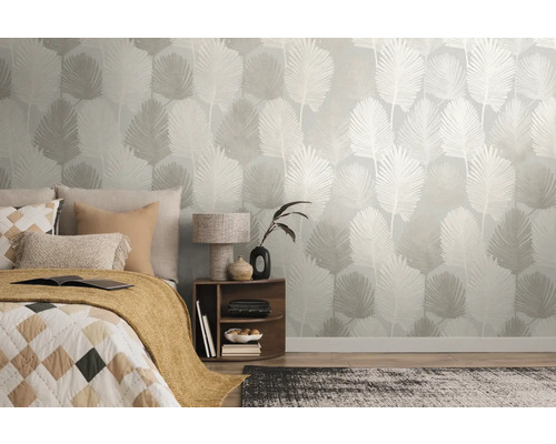 Moderne slaapkamer met vliesbehang met botanisch palmbladpatroon, gecombineerd met een bed, een houten nachtkastje en een tapijt.