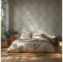 Lichte slaapkamer met palmbladbehang, houten vloer, bed met linnen beddengoed, rond jute vloerkleed en kamerplanten in het zonlicht.