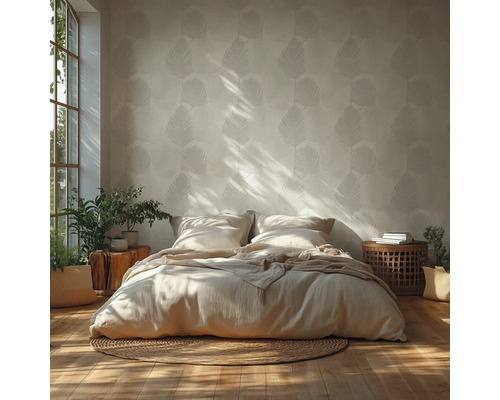 Lichte slaapkamer met behang met bladpatroon, een laag bed met neutraal beddengoed op een rond jute vloerkleed en houten accenten.