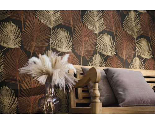 Vliesbehang met palmbladpatroon achter een houten bank met kussens en een vaas met pampasgras.