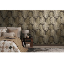 Vliesbehang met groot bladpatroon in een modern ingerichte slaapkamer met bed en nachtkastje.