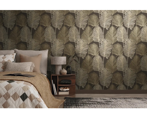 Vliesbehang met groot bladpatroon in een modern ingerichte slaapkamer met bed en nachtkastje.