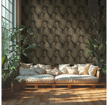 Vliesbehang met bladpatroon in een lichte woonkamer met houten bank en kamerplanten.