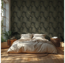 Slaapkamer met donker behang met bladpatroon, licht bed, gevlochten vloerkleed, houten vloer en kamerplanten in helder licht.
