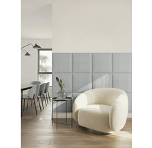 Moderne, lichte woonkamer met vierkante, beklede wandpanelen van lichtblauwe stof naast een ronde fauteuil van witte bouclé-stof.