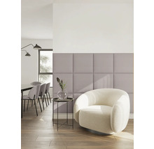 Moderne, lichte woonruimte met lila gestoffeerde wandpanelen, een witte bouclé fauteuil en een eethoek op de achtergrond.