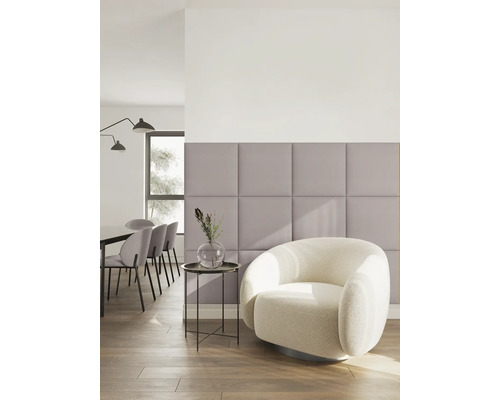 Moderne, lichte woonruimte met lila gestoffeerde wandpanelen, een witte bouclé fauteuil en een eethoek op de achtergrond.