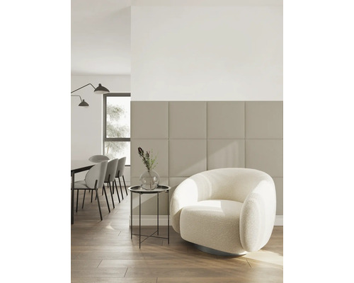 Moderne woonkamer met vierkante wandpanelen, een witte fauteuil en houten vloer in een lichte, minimalistische stijl.