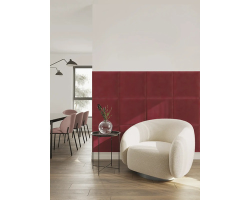 Moderne wanddecoratie met rode vierkante gepolsterde wandpanelen in een lichte woonkamer met witte fauteuil.